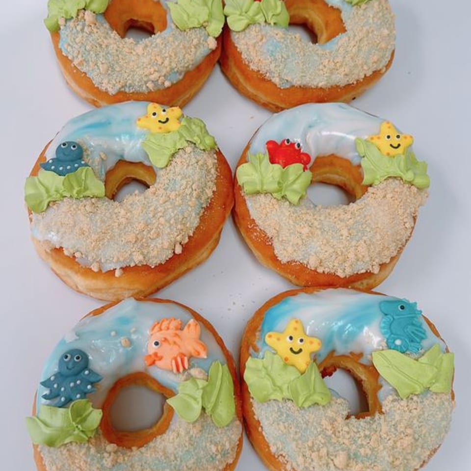 Under-the-sea beach-themed donuts with ocean icing and candy sea creatures.