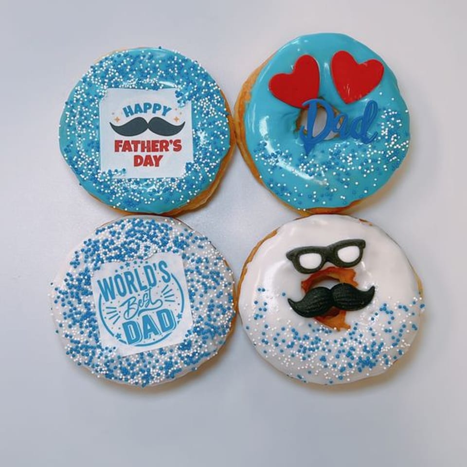 Blue and white Father's Day donuts with mustache and Dad decorations.