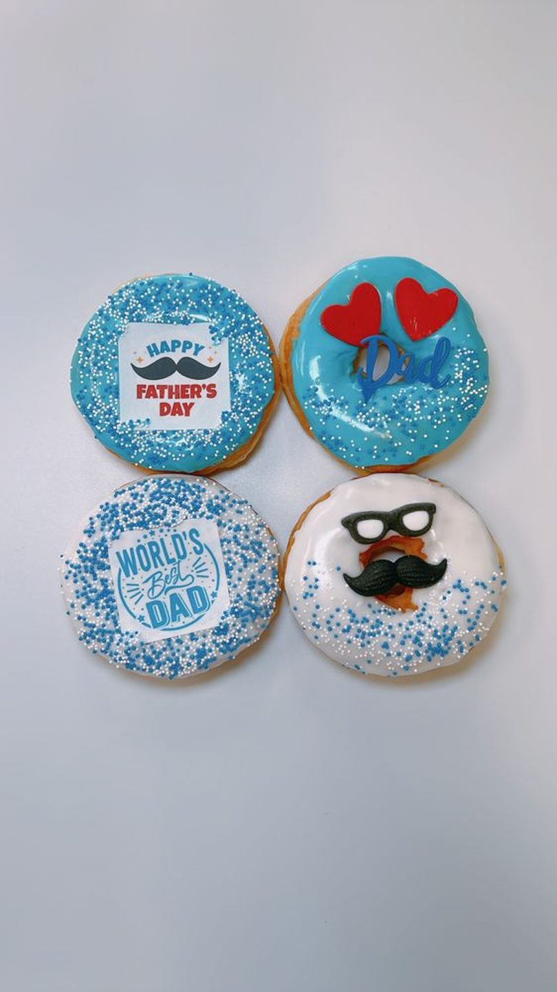 Blue and white Father's Day donuts with mustache and Dad decorations.