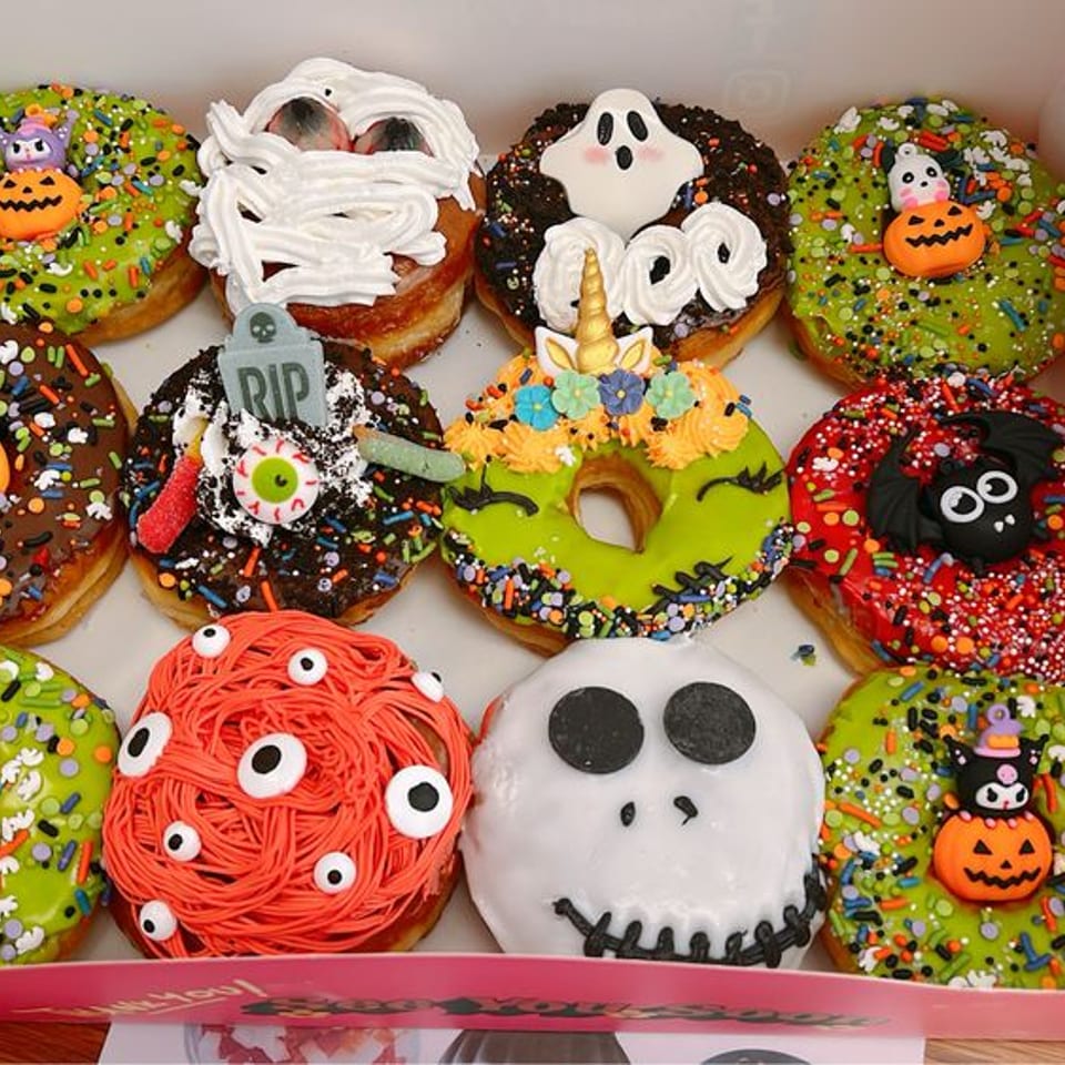 A box of a dozen Halloween-themed decorated donuts.