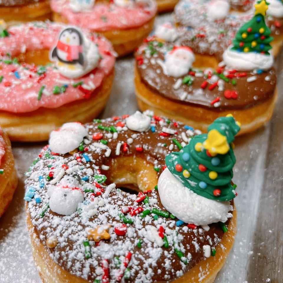 Christmas donuts with powdered sugar, holiday sprinkles, and fondant tree and Santa toppers.